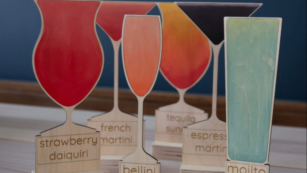 Colourful wooden drink models with engraved labels on a blue background
